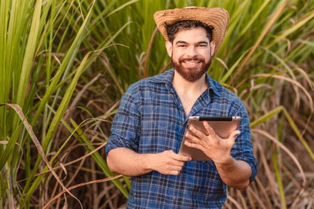 Foto de Hombre caucásico brasileño, agricultor, trabajador rural, ingeniero agrícola, tableta de retención. Agricultura y tecnología. - Imagen libre de derechos