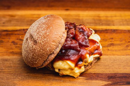 Foto de Deliciosa hamburguesa doble de ternera con queso mozzarella y salsa barbacoa. Pan australiano, descubierto. - Imagen libre de derechos
