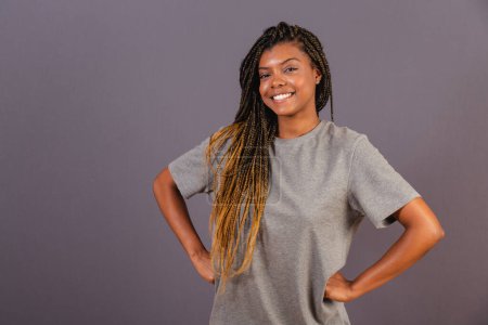 Photo for Young afro brazilian woman, hands on hips, looking at camera, smiling and confident. - Royalty Free Image