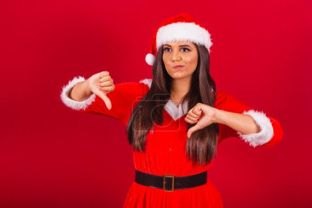 Photo for Beautiful Brazilian woman dressed in Christmas clothes, Santa Claus. dislike, negative. - Royalty Free Image
