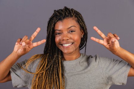 Photo for Young afro brazilian woman with peace and love sign with fingers, happy, joyful. - Royalty Free Image