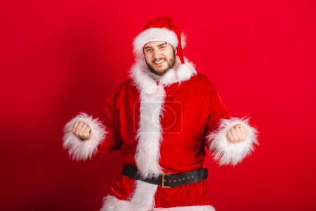 Foto de Caucásico, brasileño vestido con traje de Navidad, Santa Claus. celebrando, deseando, animando. - Imagen libre de derechos
