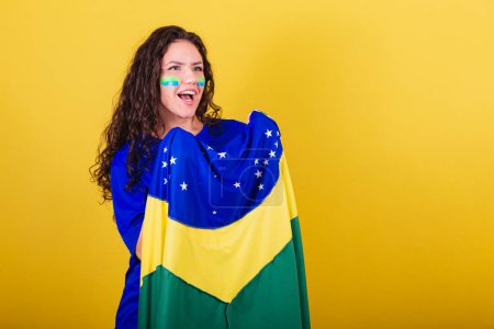 Photo for Woman soccer fan, fan of brazil, world cup, holding flag and screaming goal. - Royalty Free Image