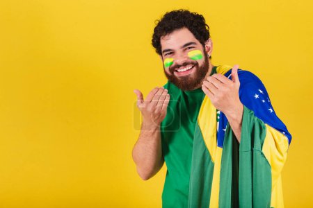 Téléchargez les photos : Homme caucasien avec barbe, brésilien, fan de football du brésil, appelant avec les mains, venez, venez, bienvenue. - en image libre de droit