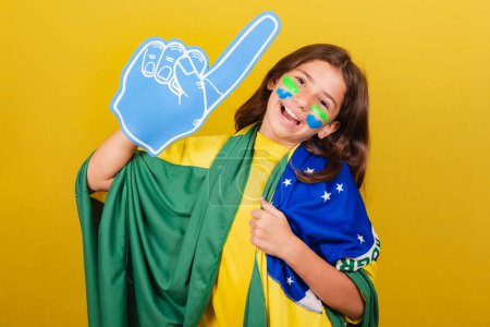 Photo for Brazilian caucasian child soccer fan with foam finger celebrating and partying. World Cup. Olympics. - Royalty Free Image