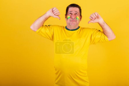 Foto de Hombre adulto, aficionado al fútbol brasileño, signo de aversión, desaprobación, desagrado, negativo. - Imagen libre de derechos