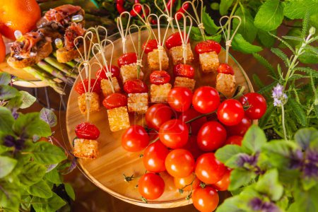Téléchargez les photos : Repas buffet gastronomique. Bâtonnets de tomates cerises avec cubes de tapioca frits au fromage. - en image libre de droit