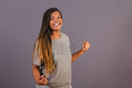 Photo for Young afro brazilian girl, vibrating with hands, celebrating, partying. yes - Royalty Free Image