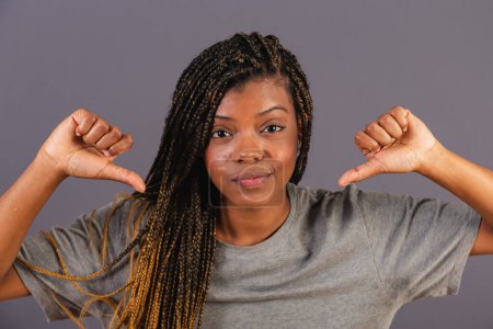Photo for Young afro brazilian, thumb down, disapproval, bad dislike. Negative. - Royalty Free Image