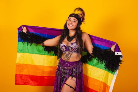 Foto de Mujer brasileña vistiendo ropa de carnaval sosteniendo bandera lgbt - Imagen libre de derechos