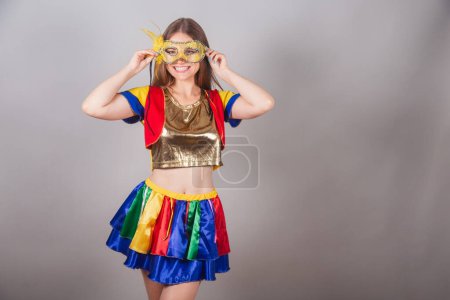Téléchargez les photos : Femme blonde brésilienne vêtue de vêtements frevo, carnaval. mettre masque de carnaval sur le visage. - en image libre de droit