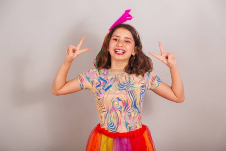Téléchargez les photos : Enfant brésilien, fille, vêtue de vêtements de carnaval, paix et amour. selfie pose. - en image libre de droit