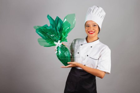 Foto de Chef jefe, cocinero brasileño, del noreste, sosteniendo un huevo de Pascua, chocolate en forma de huevo, especialista en la preparación de chocolates. - Imagen libre de derechos