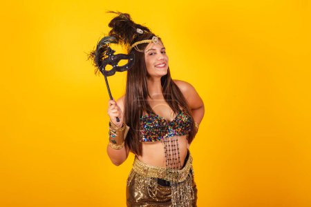 Téléchargez les photos : Belle femme brésilienne en vêtements de carnaval d'or, tenant masque de carnaval - en image libre de droit
