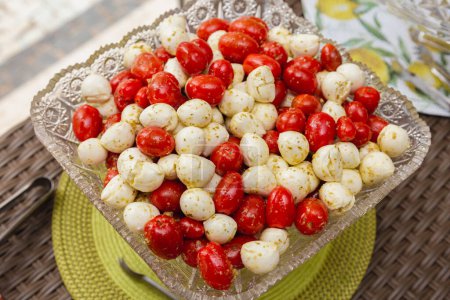 Foto de Aperitivo de fiesta, tomates cherry y queso de búfalo en salsa de aceite de oliva. - Imagen libre de derechos