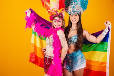 Téléchargez les photos : Deux femmes brésiliennes amies, portant des tenues de carnaval, tenant le drapeau lgb - en image libre de droit