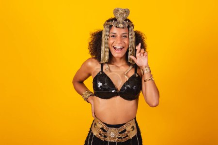 Téléchargez les photos : Belle femme brésilienne noire, en vêtements de carnaval Cleopatra, acclamant et souhaitant, doigts croisés. - en image libre de droit