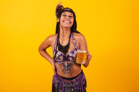 Téléchargez les photos : Belle femme brésilienne en violet vêtements de carnaval tenant verre de bière. - en image libre de droit