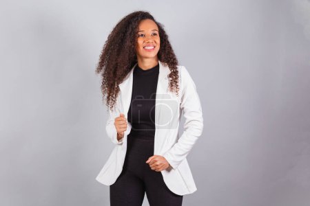 Photo for Horizontal photo, beautiful black Brazilian woman, businesswoman, wearing white suit, smiling, optimistic. - Royalty Free Image