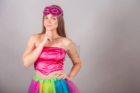 Photo for Brazilian blonde woman dressed in pink carnival clothes. wearing mascara, thinking. - Royalty Free Image