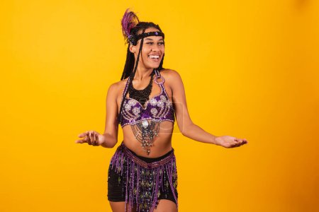 Photo for Beautiful black Brazilian woman, in purple carnival clothes, with open arms, welcome. - Royalty Free Image