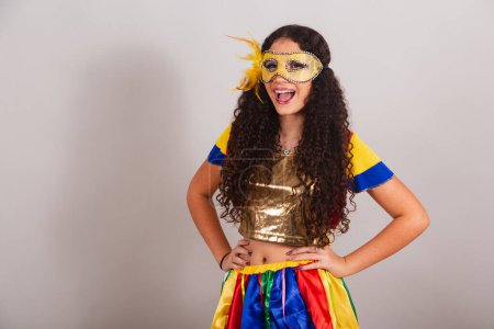 Foto de Jovencita adolescente, brasileña, con ropa frevo, carnaval. Máscara, manos en las caderas. posando para la foto. - Imagen libre de derechos