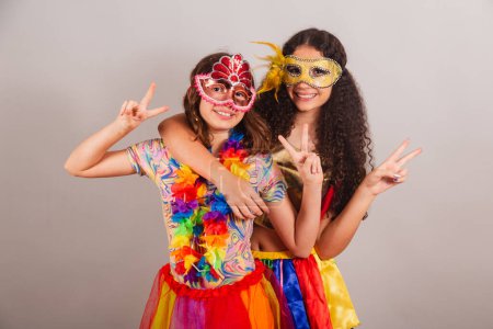 Foto de Chicas brasileñas amigas, vestidas con ropas de carnaval. abrazar sonriendo a la cámara, amistad. - Imagen libre de derechos