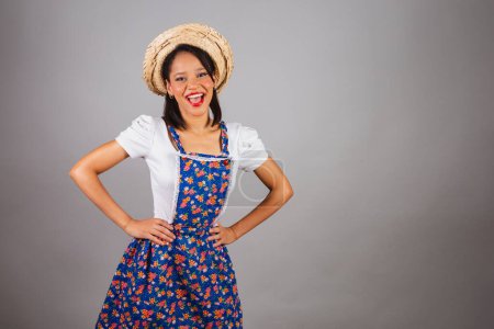 Photo for Brazilian woman, northeastern, with June party clothes, straw hat. Hands on hips. - Royalty Free Image
