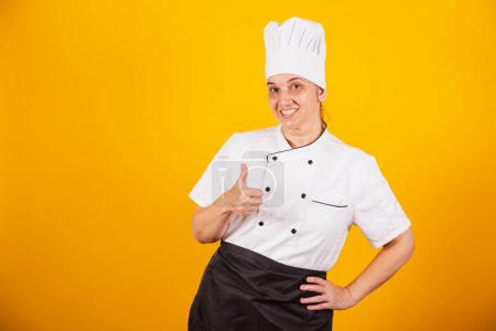Photo for Adult Brazilian woman, chef, master in gastronomy. Cook. Thumb up, positive. - Royalty Free Image
