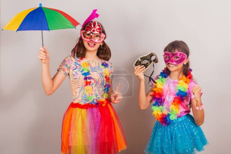 Foto de Dos niños brasileños, niñas, amigos, vestidos con ropas de carnaval, bailando. - Imagen libre de derechos