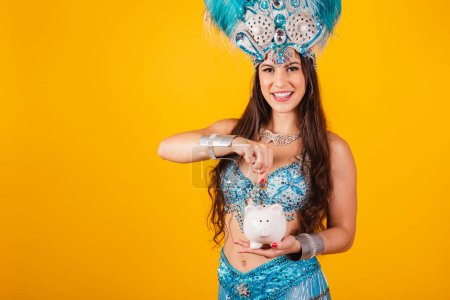 Téléchargez les photos : Belle femme brésilienne avec des vêtements de reine de l'école de samba, carnaval. Couronne de plumes, tenant tirelire et pièce de monnaie. - en image libre de droit