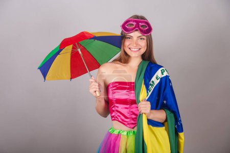 Foto de Mujer rubia brasileña vestida con ropa de carnaval rosa. paraguas frevo con bandera de Brasil. - Imagen libre de derechos