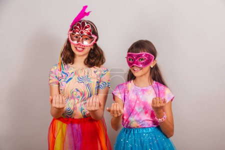 Téléchargez les photos : Deux enfants brésiliens, filles, vêtus de vêtements de carnaval, invitant de leurs mains. - en image libre de droit