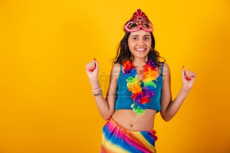 Téléchargez les photos : Belle femme brésilienne en vêtements de carnaval, portant un masque de carnaval fleur collier danse. - en image libre de droit