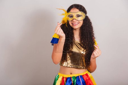 Téléchargez les photos : Jeune adolescente, brésilienne, avec des vêtements frevo, carnaval. mascara, signe du coeur avec les doigts. - en image libre de droit