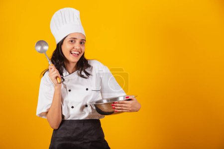 Foto de Mujer brasileña, chef jefe, cocinera, sosteniendo cuchara y tazón. mezcla. - Imagen libre de derechos