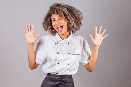 Photo for Young black Brazilian woman, cook, masterchef, wearing restaurant uniform. unbelievable, wow, unbelievable. - Royalty Free Image