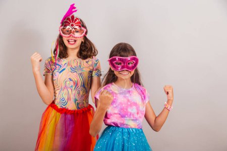 Téléchargez les photos : Deux enfants brésiliens, filles, vêtus de vêtements de carnaval, célébrant. - en image libre de droit