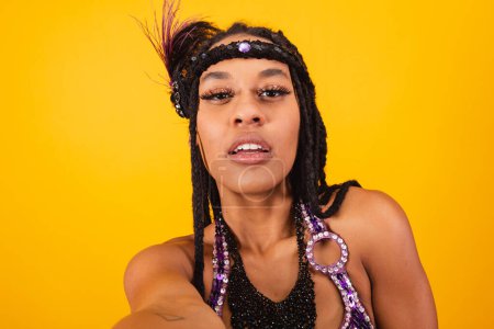 Photo for Beautiful black Brazilian woman, in purple carnival clothes, taking self portrait. - Royalty Free Image