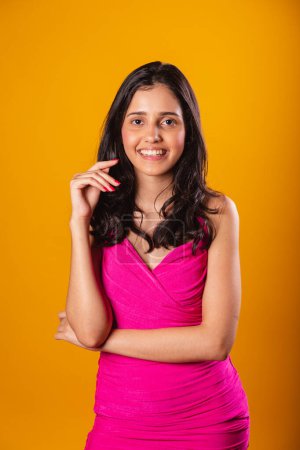 Téléchargez les photos : Femme brésilienne, avec robe rose, en fond photographique jaune, Photo posant en photo verticale. - en image libre de droit
