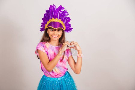 Photo for Beautiful Brazilian girl, child, dressed for carnival in Brazil. heart sign with hands. - Royalty Free Image