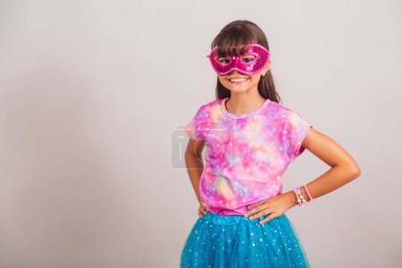 Foto de Hermosa chica brasileña, niña, vestida para el carnaval en Brasil. con máscara de carnaval, las manos en la cintura. - Imagen libre de derechos