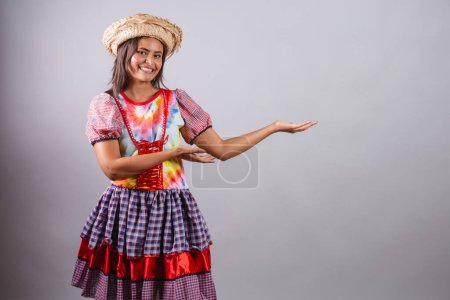 Photo for Brazilian woman wearing country clothes, So Joo party, Junina party. presenting product, presenting advertisement, advertisement. - Royalty Free Image