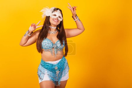 Téléchargez les photos : Belle femme brésilienne en bleu et blanc vêtements de carnaval. faire la paix et l'amour pose. - en image libre de droit