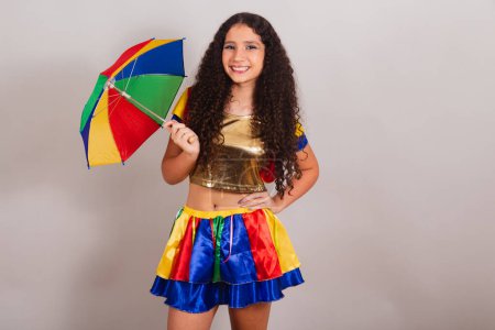 Photo for Young teen girl, brazilian, with frevo clothes, carnival. with umbrella and hands on waist. - Royalty Free Image