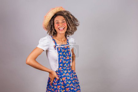 Photo for Young black Brazilian woman, with country clothes, dressed for Festa Junina. Saint John's festival. hands on waist. - Royalty Free Image