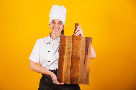 Photo for Adult Brazilian woman, chef, master in gastronomy. holding wooden board. - Royalty Free Image