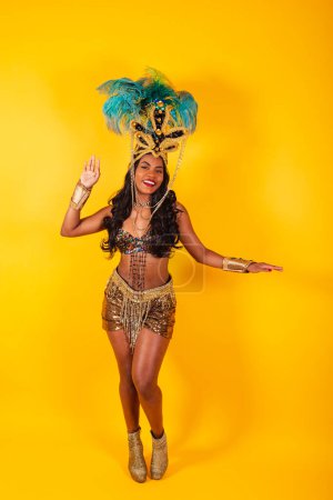 Téléchargez les photos : Photo verticale, corps entier, femme brésilienne noire en vêtements de carnaval posant pour une photo. - en image libre de droit