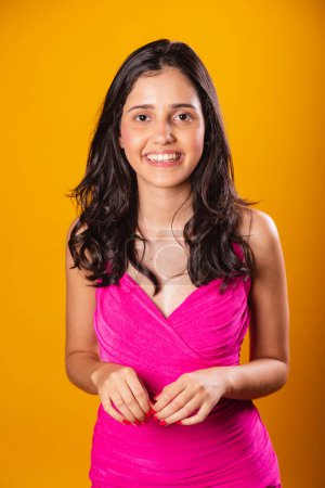 Photo for Brazilian woman, with pink dress, in yellow photographic background, Photo posing in vertical photo. - Royalty Free Image
