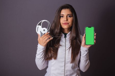 Photo for Horizontal photo. brazilian woman with medical coat, nutritionist. adipometer and smartphone, green screen. slimming. - Royalty Free Image